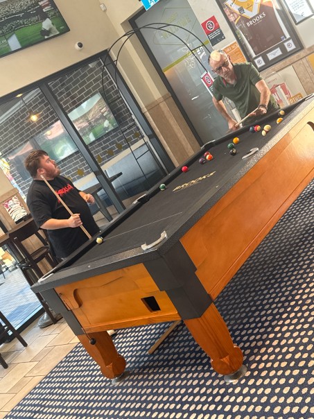Two friends playing a game of pool
