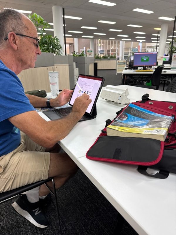 Man sitting at a desk using a tablet